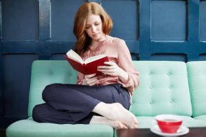 Woman-reading-a-book-on-sofa-2043550