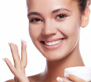 girl-applying-moisturizer-to-face-smiling