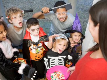 Six children in costumes trick or treating at woman’s house