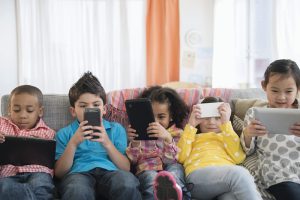Children using technology on sofa