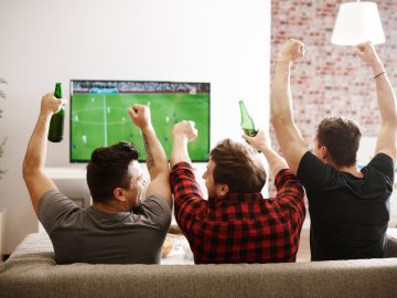 Rear view of men watching match and cheering