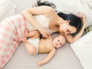 Happy young mother and cute baby on light background.